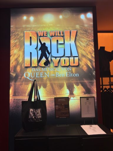 Plakat für das Musical „We Will Rock You“ von Queen, mit einem Rockstar-Silhouette.