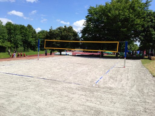 Blick auf einen Sandvolleyballplatz mit Netzanlage unter blauem Himmel.